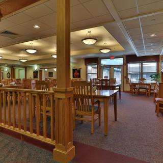 A quiet library interior featuring wooden tables and chairs for reading and study.
