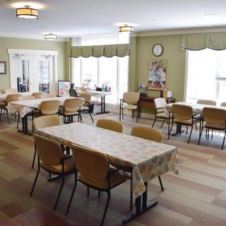 An empty dining hall with neatly arranged tables and chairs, ready for guests.
