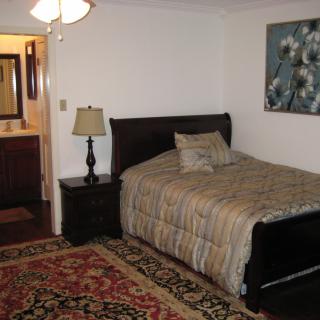 A cozy bedroom with a single bed, nightstand, and decorative rug.