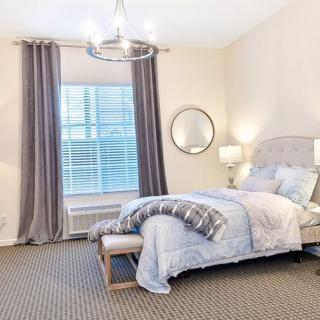 A modern and elegantly designed bedroom with soft lighting and neutral colors.
