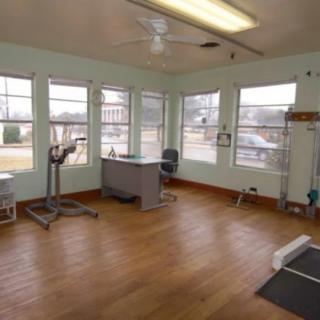 A spacious office with a desk and chair, surrounded by large windows.