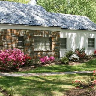 A charming house with a beautifully landscaped garden and blooming flowers.