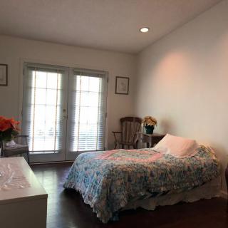 A minimalist bedroom with a bed, decor, and large windows.