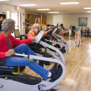 Seniors engaging in exercise routines on specialized equipment in a rehabilitation center.