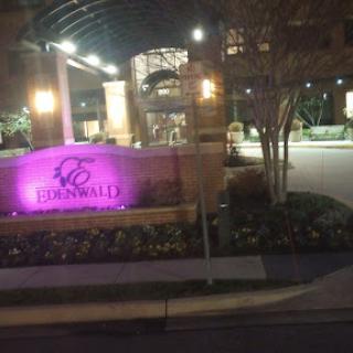 A night view of a building entrance with illuminated signage.