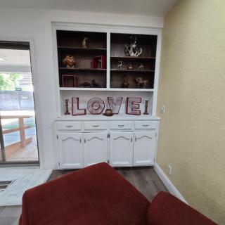 Cozy living room corner with a decorative bookshelf and LOVE sign.
