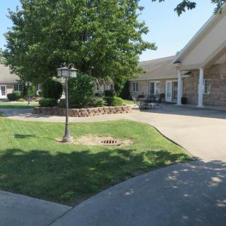 A serene courtyard with a tree, lamp post, and surrounding buildings.