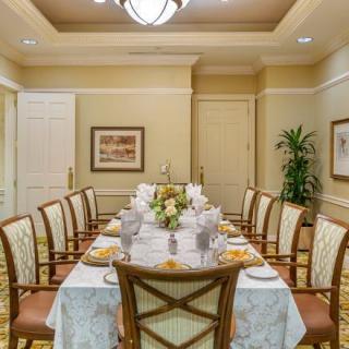 A formal dining room with an elegantly set table and classic decor.