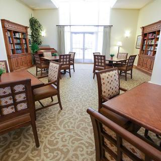 A cozy library reading area with wooden furniture and bookshelves.
