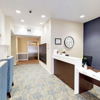 A modern office reception area with a desk and hallway.