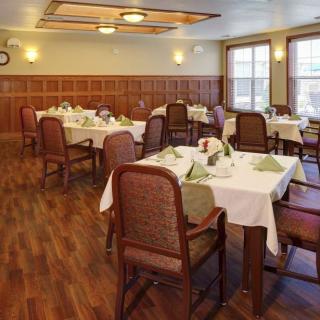 A cozy dining room with neatly arranged tables and chairs, set for a meal.