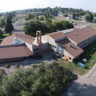 Aerial view of a school building surrounded by trees.