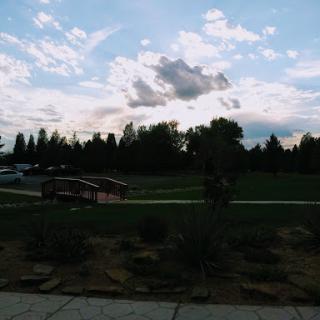 A serene view of a park with scattered clouds in the evening sky.