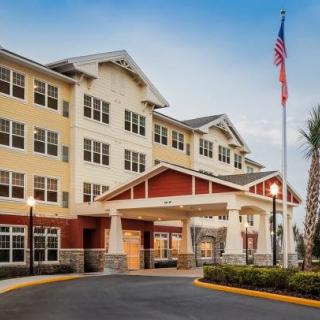 A modern hotel building with an entrance canopy and an American flag flying outside.