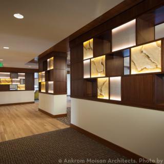 A modern reception area featuring elegant wood paneling and illuminated decorative elements.