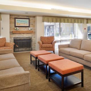 A cozy living room with sofas, armchairs, and a fireplace.