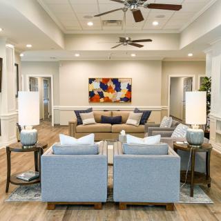 A modern living room with a comfortable seating area, vibrant artwork, and soft lighting.