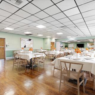 A spacious dining area set with neatly arranged tables and chairs, perfect for gatherings or meals.