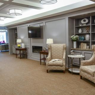 A cozy living room area with plush chairs, bookshelves, and a television.