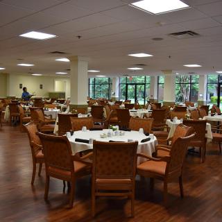 An empty dining room with neatly arranged tables and chairs.