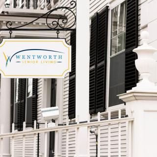 A business sign reading 'Wentworth's' attached to a white building with black shutters.
