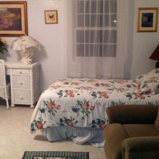A cozy bedroom with a floral bedspread and a small nightstand.