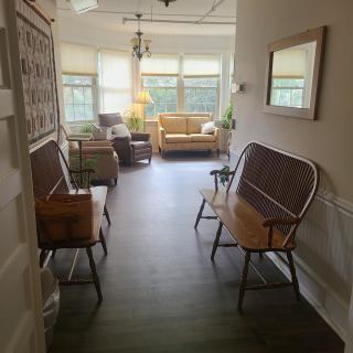 A cozy waiting area with benches and a sofa near large windows.