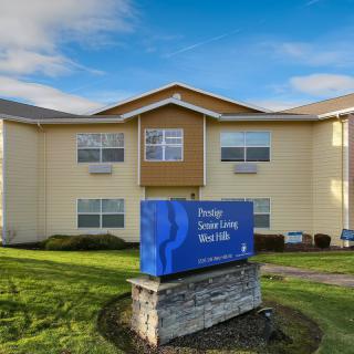 A retirement living facility with a prominent blue sign in front of a well-maintained lawn.