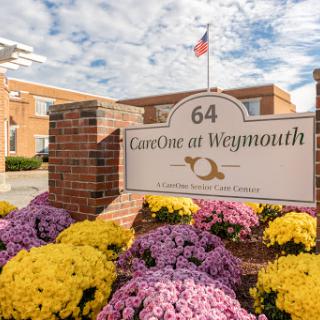 Entrance to CareOne at Weymouth with vibrant flowers in bloom.