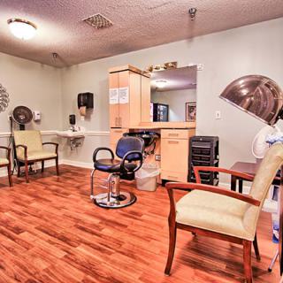 A cozy salon interior featuring styling chairs, mirrors, and hair dryers on a wooden floor.