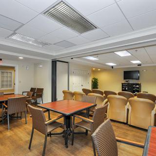 A well-arranged meeting room with tables, chairs, and a large screen for presentations.