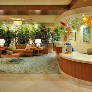 A welcoming hotel lobby featuring comfortable seating and lush indoor plants.