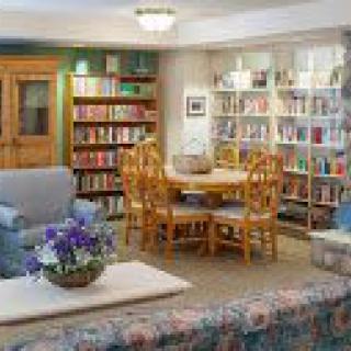 A cozy library room with bookshelves and comfortable seating.