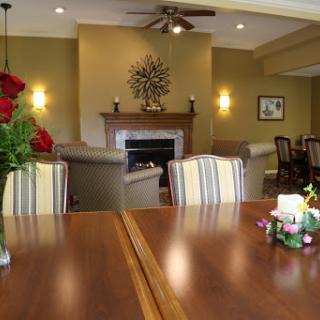 A warm and inviting living space with a stylish dining area, adorned with fresh flowers and a cozy fireplace.