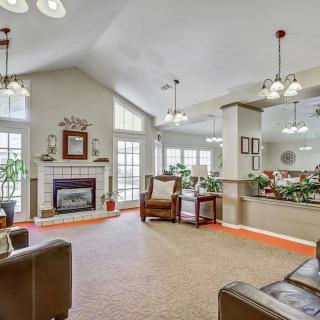 A spacious living room with a fireplace, comfortable seating, and large windows allowing natural light.