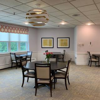 A spacious and well-lit dining area featuring tables and chairs arranged for a cozy atmosphere.