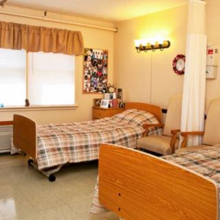 A hospital room with two twin beds and a curtain divider.