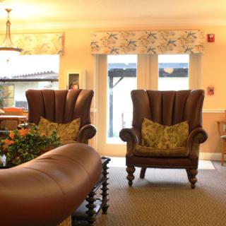 A cozy living room featuring two large wingback armchairs and warm ambient lighting.