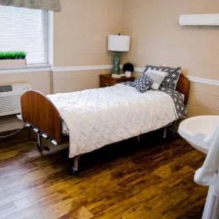 A cozy, simply decorated bedroom with a single bed and wooden flooring.