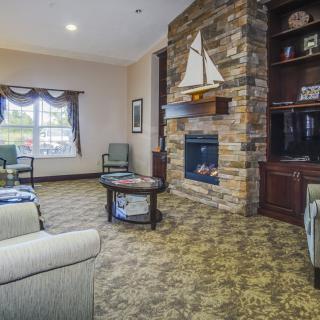 A cozy living room featuring a stone fireplace and sailing-themed decor.