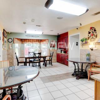Spacious kitchen and dining area with tiled flooring and ample lighting.
