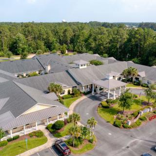 Aerial view of a large building surrounded by lush greenery.
