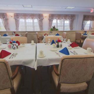 A well-set dining room with tables arranged for a meal, featuring colorful napkins and stylish decor.