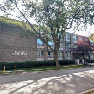 A view of a modern educational building surrounded by trees.
