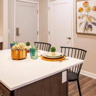 A modern kitchen island with a stylish table setting and artwork on the wall.