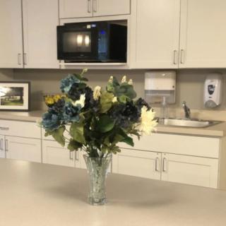 A kitchen with a vase of colorful flowers on the countertop.