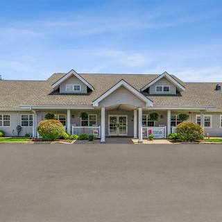 A charming single-story house with a large front porch and manicured landscaping.