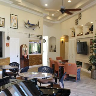 A cozy lobby with comfortable seating, a television, and decorative elements on the walls.