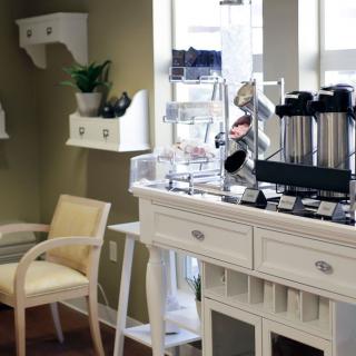 A cozy waiting area with a modern coffee station and stylish furniture.