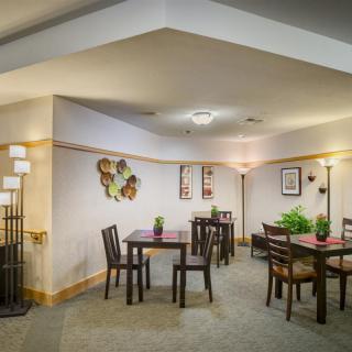 A cozy indoor dining area with neatly arranged tables, chairs, and decorative elements.